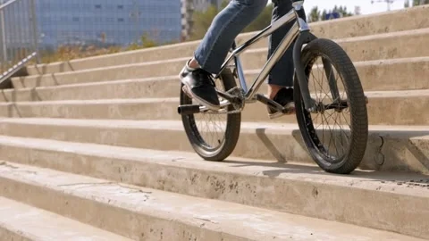 Close up a young guy does stunts on a BMX bike in the Park on the stairs. Stock Footage 143790082
