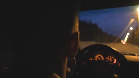 Close up of young guy holds hands on steering wheel and drives a modern Vidéo 333977012