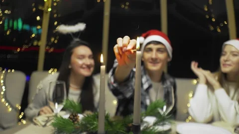Close-up of a young guy lights candles. Friends celebrate the New Year at the Stock Footage 167245859