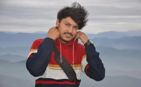Close-up of a young guy looking at camera, adjusting collar while standing  Stock Photos