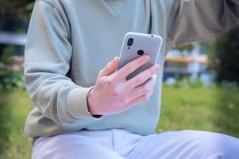 Close up of young guyusing smartphone app outdoors. Stock Photos