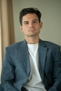 Close-up of young handsome guy in a white shirt, looks seriously and intently at Foto stock