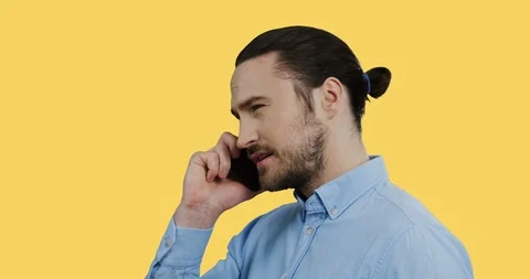 Close up of the young handsome man in the blue shirt talking on the phone while Stock Footage 104171685