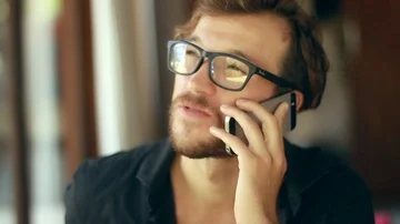 Close up on the young handsome man is speaking on the smartphone. Video stock 85524209