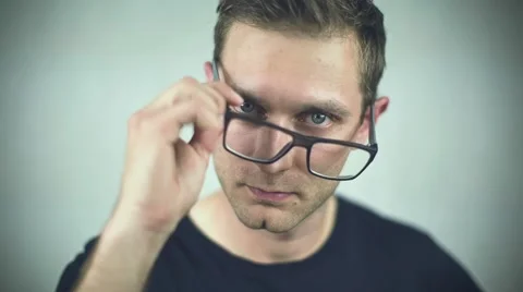 Close up of young handsome man, taking off glasses over white background 動画素材 40802954