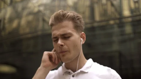 Close-up of a young handsome student guy listening to his favorite online radio Stock Footage 114454241