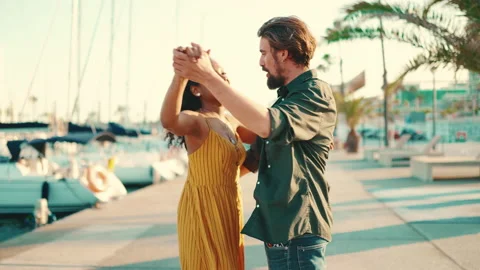 Close-up of young happy man and woman joyful dancing on the embankment on yacht Video stock 226881979