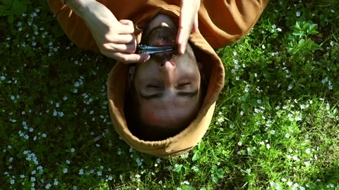 Close up of young happy man resting on forest white flowers playing on vargan 스톡 동영상 154412447