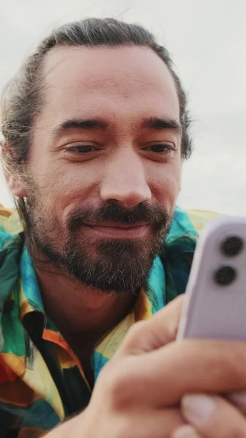 Close up, young happy man using mobile phone on the beach Stock Footage 227136472
