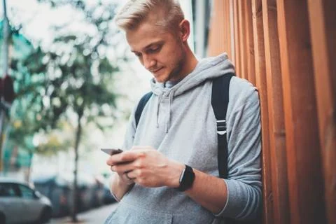 Close-up of young hipster man using smartphone device outside Stock Photos