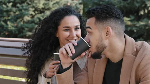 Close up young hispanic couple sitting on bench in autumn city park man and Stock Footage 167128823