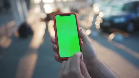 Close-up young human holding a smartphone swiping tapping on green screen chrome Stock Footage 112062201