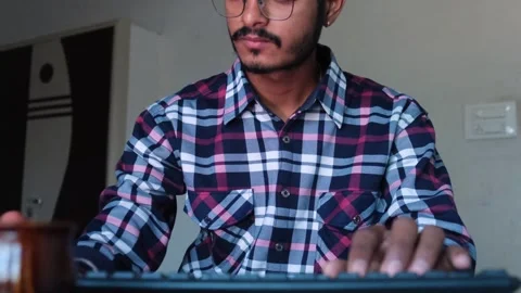 Close-up of a young Indian man with glasses typing on a computer keyboard Stock-Footage 329921925