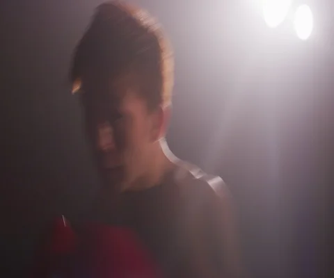 Close up of young Japanese man practising hitting and punching with red gloves Stock Footage 147051045