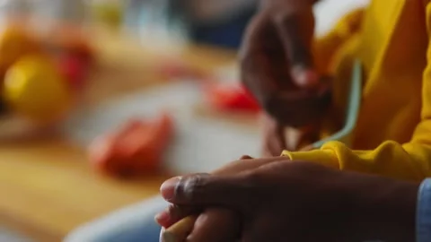 Close-up young kid learning to play guitar with help of father using kitchen Stock Footage 147271393