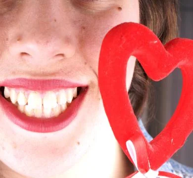 Close up of a young lady face with a red heartshape object Stock Photos