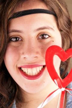 Close up of a young lady face with a red heartshape object Stock Photos