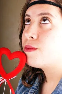 Close up of a young lady face with a red heartshape object Stock Photos