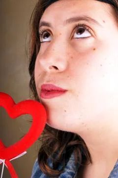 Close up of a young lady face with a red heartshape object Stock Photos