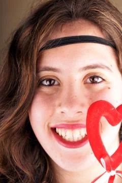 Close up of a young lady face with a red heartshape object Stock Photos