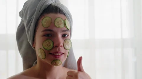 Close-up of Young Lady Smiling with Cucumber Slices on Face and Towel Wrapped Stock Footage 308593831