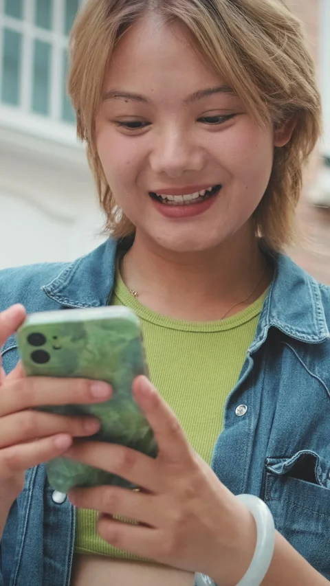 Close-up of young laughing woman using mobile phone Video stock 252208033