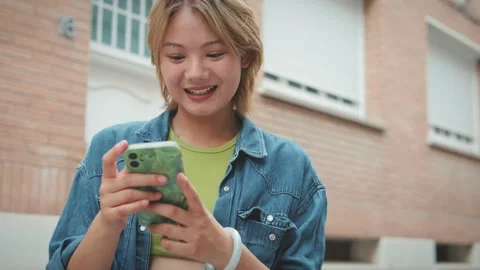 Close-up of young laughing woman using mobile phone Stock Footage 252505225