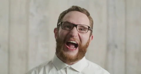 Close up young mad angry man in basic white shirt looking at camera screaming. Stock Footage 170485009