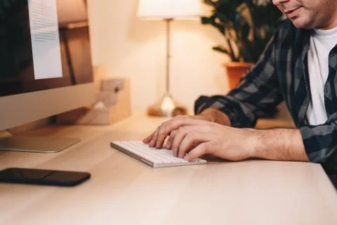 Close up of a young male freelancer using a computer, working from a home off Foto stock