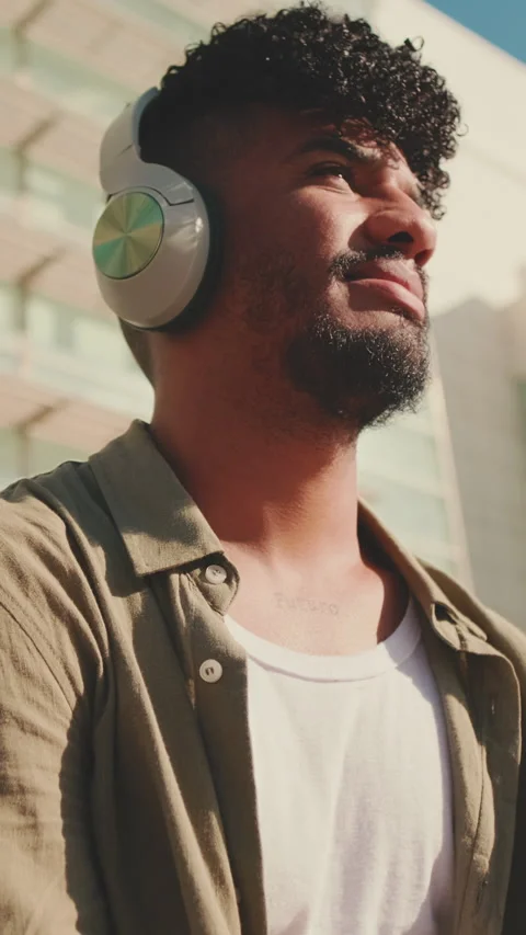 Close up, young male student dressed in an olive-colored shirt sits outside next Stock Footage 226859928