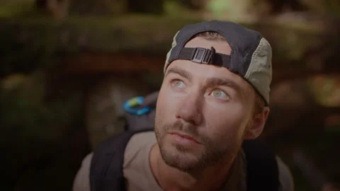 Close up of young males face looking up at forest in surprise 库存影片 220301672