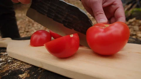 Close up of young man appearance cuts tomatoes on wooden board Stock Footage 303372346