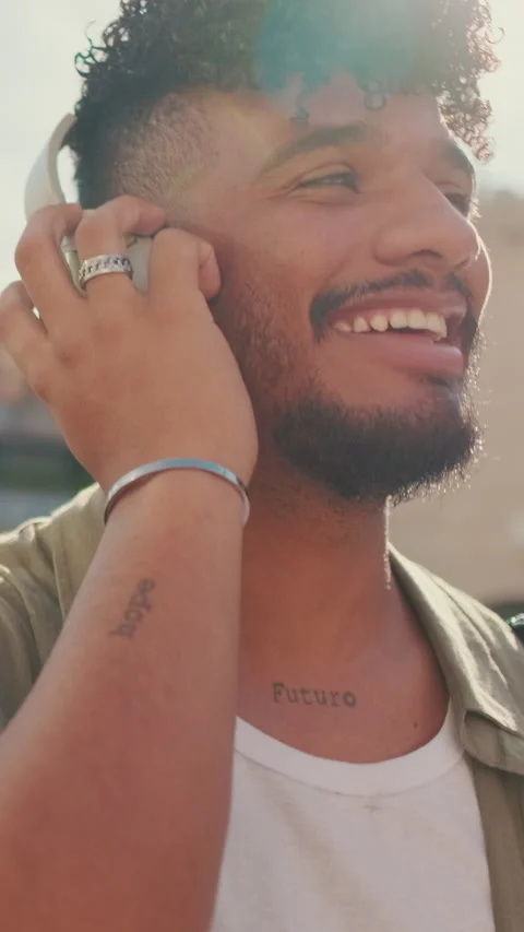Close up, young man with beard in an olive-colored shirt listens to music on Stock Footage 226859729