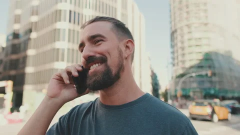 Close-up of young man with beard talking on the phone on traffic cars background Stockbeeldmateriaal 226900192