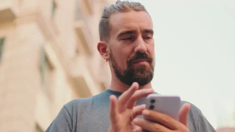 Close up, young man with beard uses map application on mobile phone Video stock 226897331