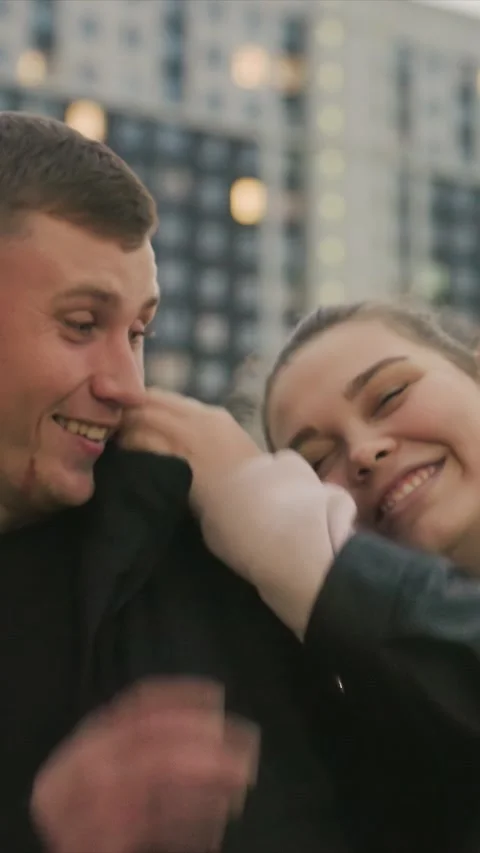 Close up of young man in black jacket with unseen person hand touching ear Stock Footage 345543921