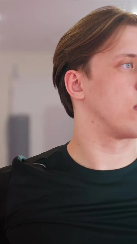 Close up young man in black shirt adjusting posture with hands on head or behind Stock Footage 343090730