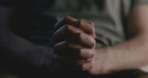 CLOSE UP of a young man bringing hands together to pray whilst breathing deeply. Stock Footage 194452508