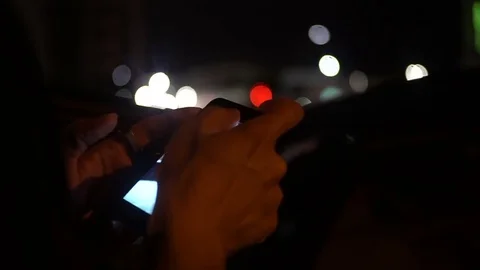Close up of a young man browsing his iphone at night Stock Footage 75325041