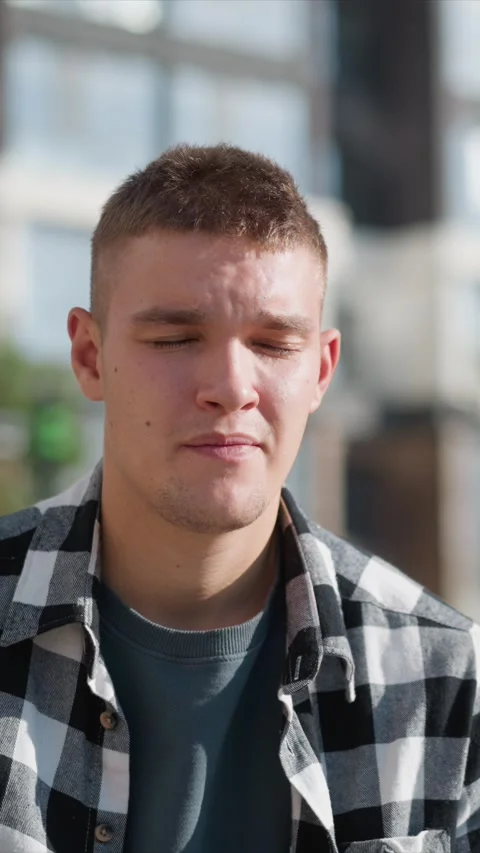 Close up of young man in checkered shirt standing outdoors under sunlight with Stock Footage 345081251