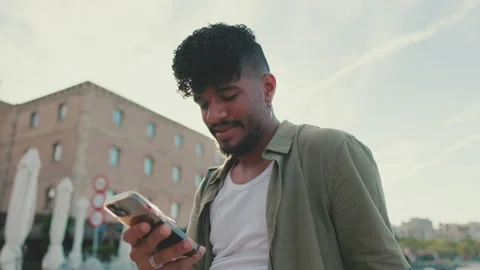 Close up, young man dressed in an olive-colored shirt is sitting on the Stock Footage 226848027