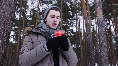 Close up of young man drinking hot tea on a winter day 스톡 동영상 70989719