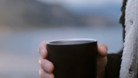 Close up young man drinks tea or coffee from a black thermo cup Stock Footage 105106239