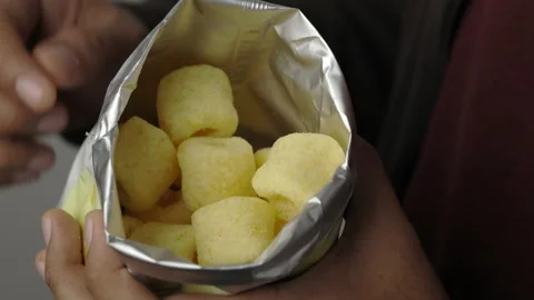 Close up Young man eating Crispy french fries in paper bag. Fast food or junk fo Stock Footage 152806393