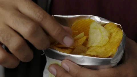 Close up Young man eating Crispy Potato chips salty snacks in paper bag. Fast fo Stock Footage 152806639