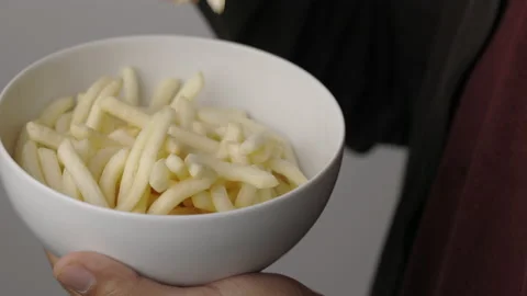 Close up young man eating crispy potato salty snacks in bowl. Fast food or junk  Video stock 152806937