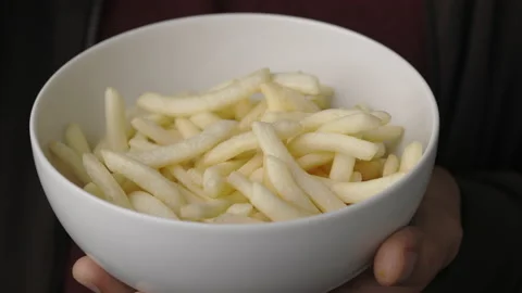 Close up young man eating crispy french fries salty snacks in bowl. Fast food or Stock Footage 152806939
