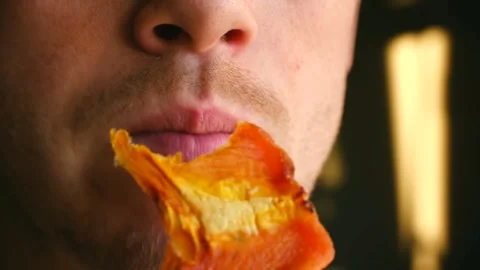 Close up of a young man eating dried persimmon fruit Stock Footage 337547349