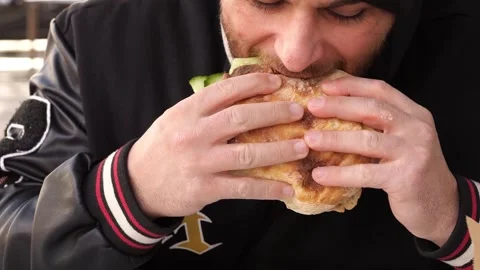 Close-up of Young Man Eating a Fresh Doner Kebab Sandwich Stockbeeldmateriaal 332137361