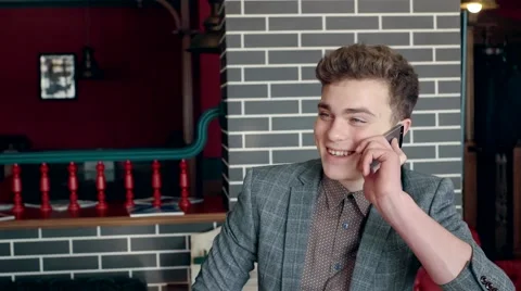 Close up of a young man enjoying in cafe talking on a mobile phone. Stock-Footage 61388357